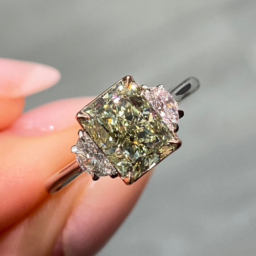 Natural green diamond engagement ring with a radiant cut center and yellow diamond accents.