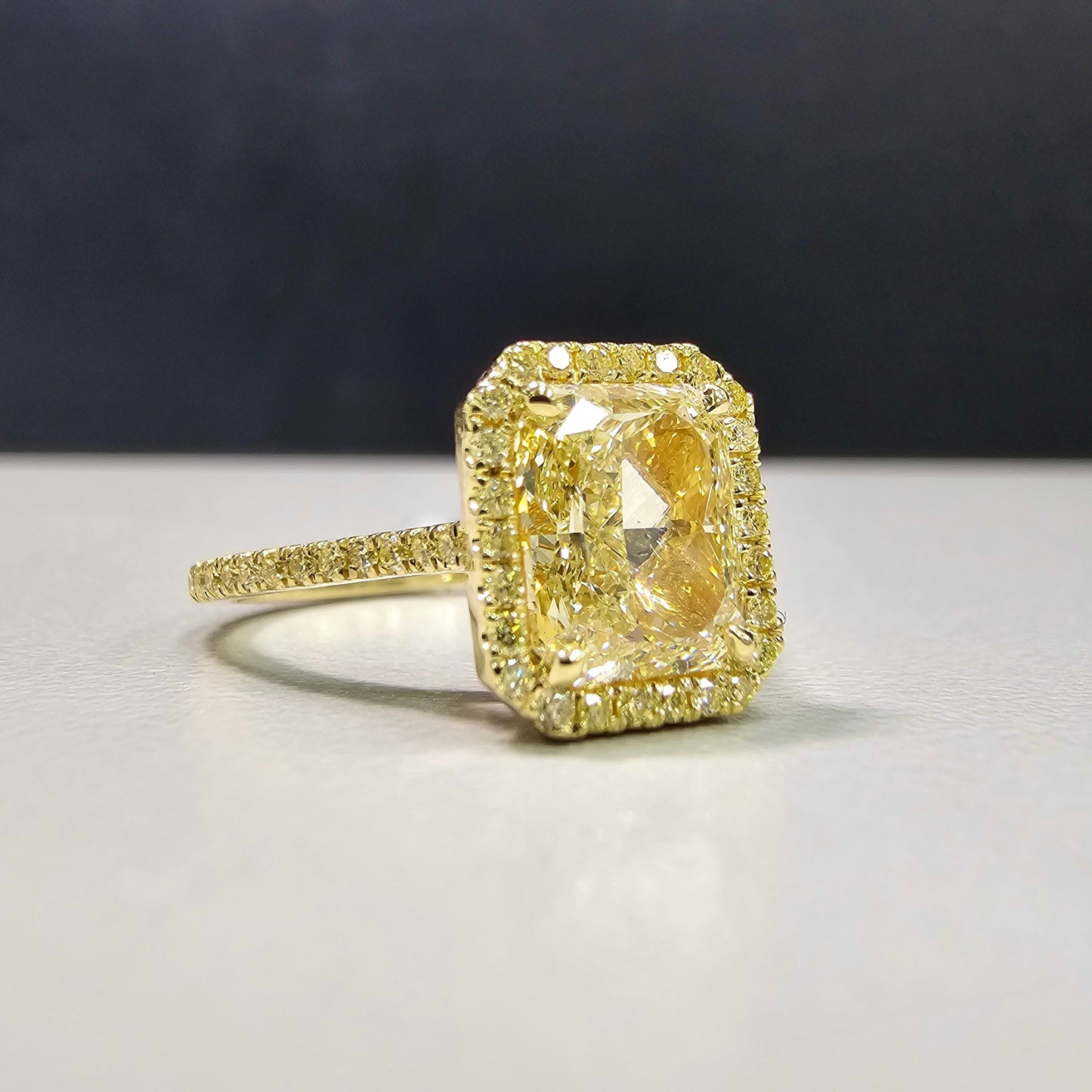2.28 Carat Center Diamond GIA Light Yellow Diamond (Y-Z) Radiant Cut Diamond 0.30 Carats of Fancy Yellow Rounds VS1 Clarity Medium Blue Fluorescence Excellent, Very Good cutting Set in 18k Yellow Gold GIA Certified Diamond Handmade in NYC