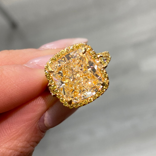 Unique light yellow cushion diamond ring with yellow diamond halo setting.