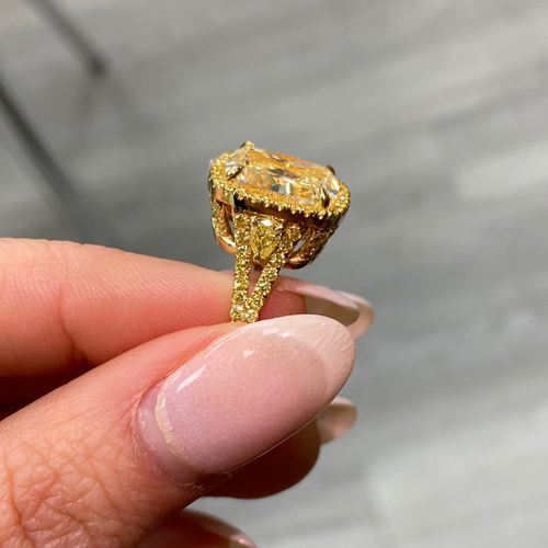 Unique light yellow cushion diamond ring with yellow diamond halo setting.