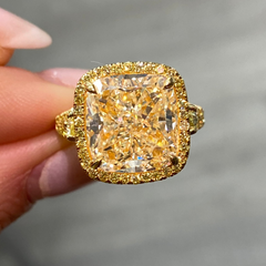 Unique light yellow cushion diamond ring with yellow diamond halo setting.