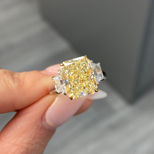 Elegant fancy light yellow elongated radiant diamond ring with VS2 clarity, unique and striking design.