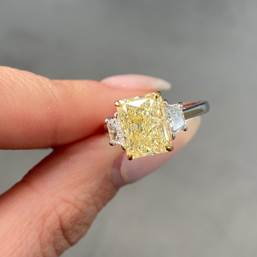 Fancy light yellow elongated radiant cut diamond engagement ring with VVS2 clarity.