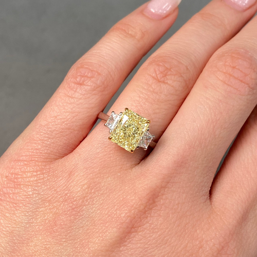 Fancy light yellow elongated radiant cut diamond engagement ring with VVS2 clarity.