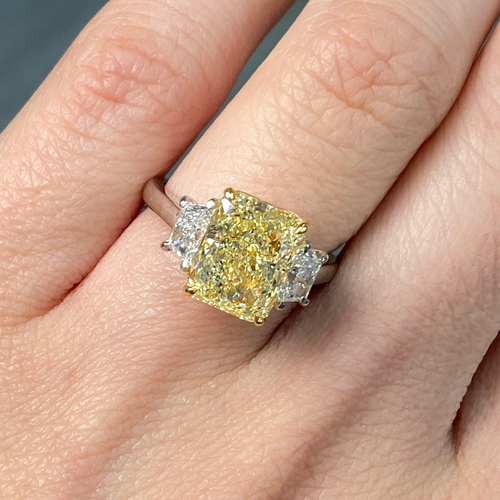 Fancy light yellow elongated radiant cut diamond engagement ring with VVS1 clarity.