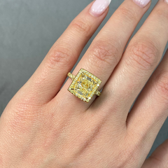 GIA certified light yellow elongated cushion cut halo diamond engagement ring with canary yellow, SI1 clarity.