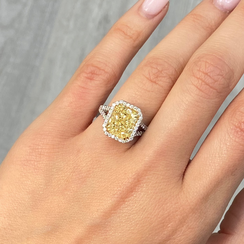 Light yellow radiant cut diamond engagement ring with a white diamond halo, VS2 clarity.