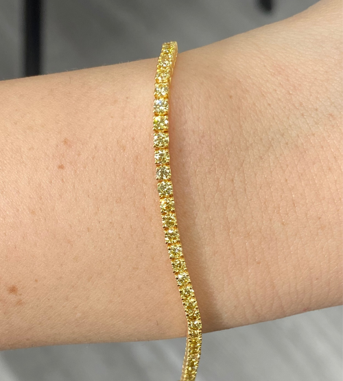 Fancy round shaped intense yellow diamond tennis bracelet, GIA certified with VS clarity.