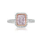 Pink diamond engagement ring surrounded by a white diamond halo