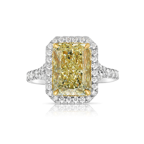 GIA certified light yellow elongated radiant diamond halo engagement ring with white diamonds.