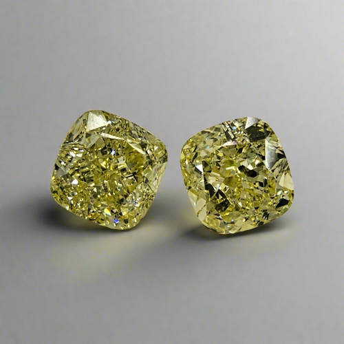 Matched pair yellow diamond rings with a soft yellow hue and elegant cushion cut.