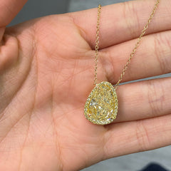 Old money light yellow pear-shaped diamond pendant, accented by a radiant halo of yellow diamonds with SI1 clarity.