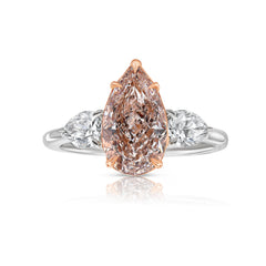 Elegant pink pear-shaped diamond engagement ring with VS1 clarity and sparkling side stones.