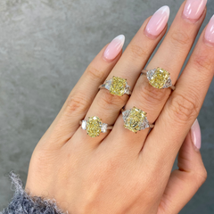 Photo of 4 fancy yellow diamond engagement rings on a female hand 