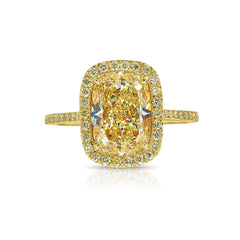 Old Money Yellow elongated cushion diamond ring surrounded by a yellow diamond halo set in yellow gold.