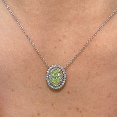 Fancy yellow-green oval diamond pendant with a double halo design and SI1 clarity.