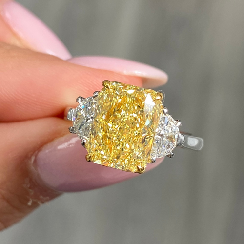 Fancy engagement ring with a yellow diamond center and two white diamonds on the sides.