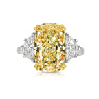 Elongated cushion cut fancy yellow diamond engagement ring with two side diamonds.