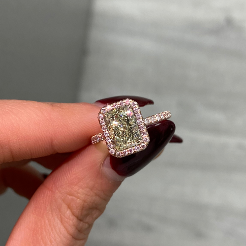 Fancy greenish-yellow radiant cut diamond halo ring with pink diamonds and VS2 clarity.