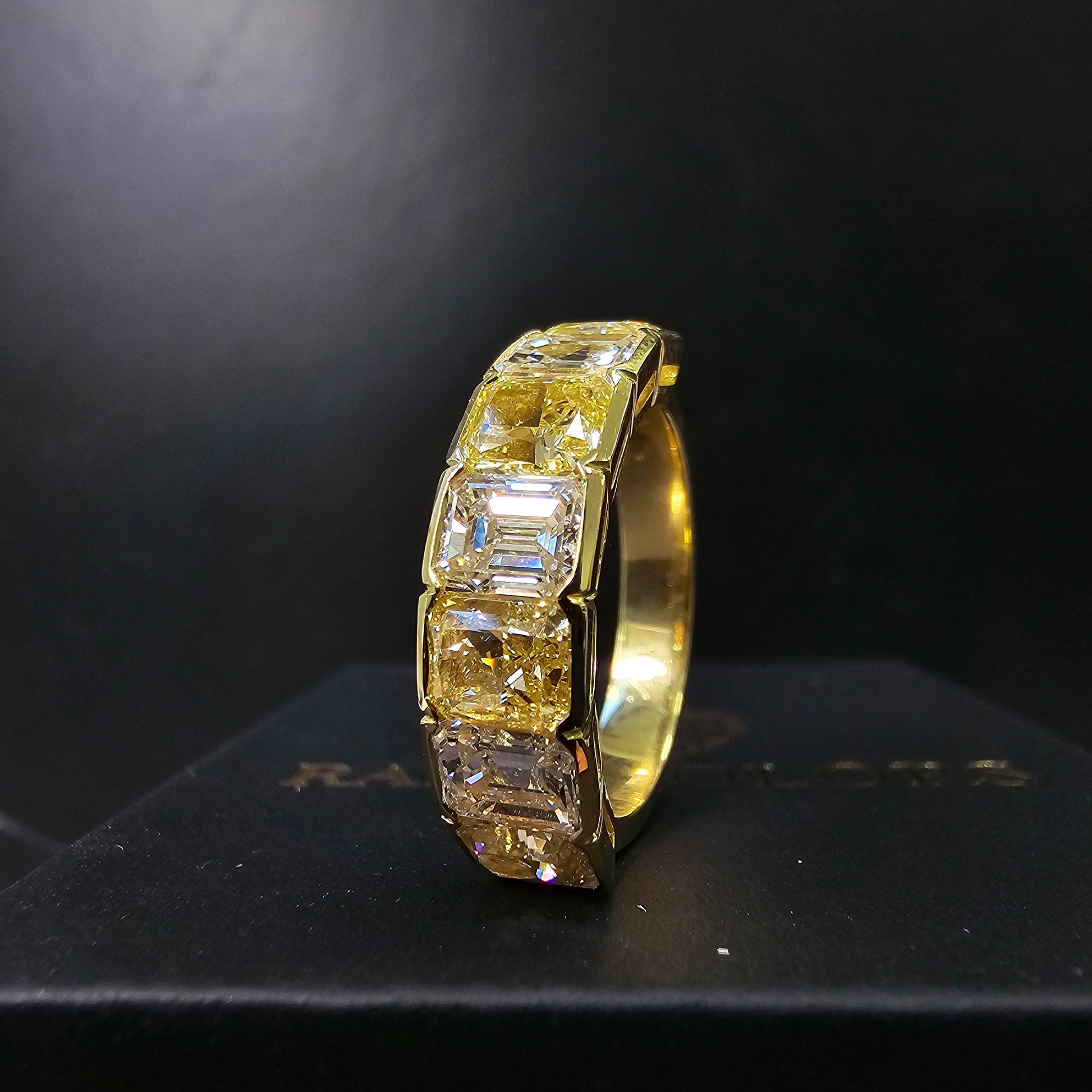 An alternating yellow diamond and white diamond half eternity band, a twist on the classic eternity with diamonds reaching only halfway across the band