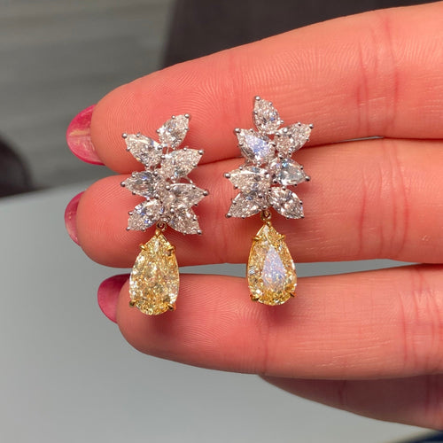 Fancy Light Yellow pear shape diamond earrings Natural yellow pear shape diamond cluster drop earrings with a total of 13.29 carats of natural white and yellow diamonds. Featuring 3 carat each, GIA Certified Fancy Light Yellow pear shape center diamonds with VS1 and VVS2 clarity.