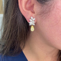 Fancy Light Yellow pear shape diamond earrings Natural yellow pear shape diamond cluster drop earrings with a total of 13.29 carats of natural white and yellow diamonds. Featuring 3 carat each, GIA Certified Fancy Light Yellow pear shape center diamonds with VS1 and VVS2 clarity.