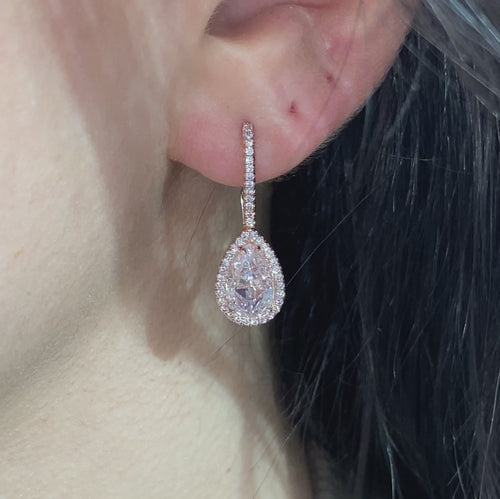 Handmade rose gold earrings featuring a rare matched pair of 2 carat each light pink pear shape diamonds and round pink diamonds