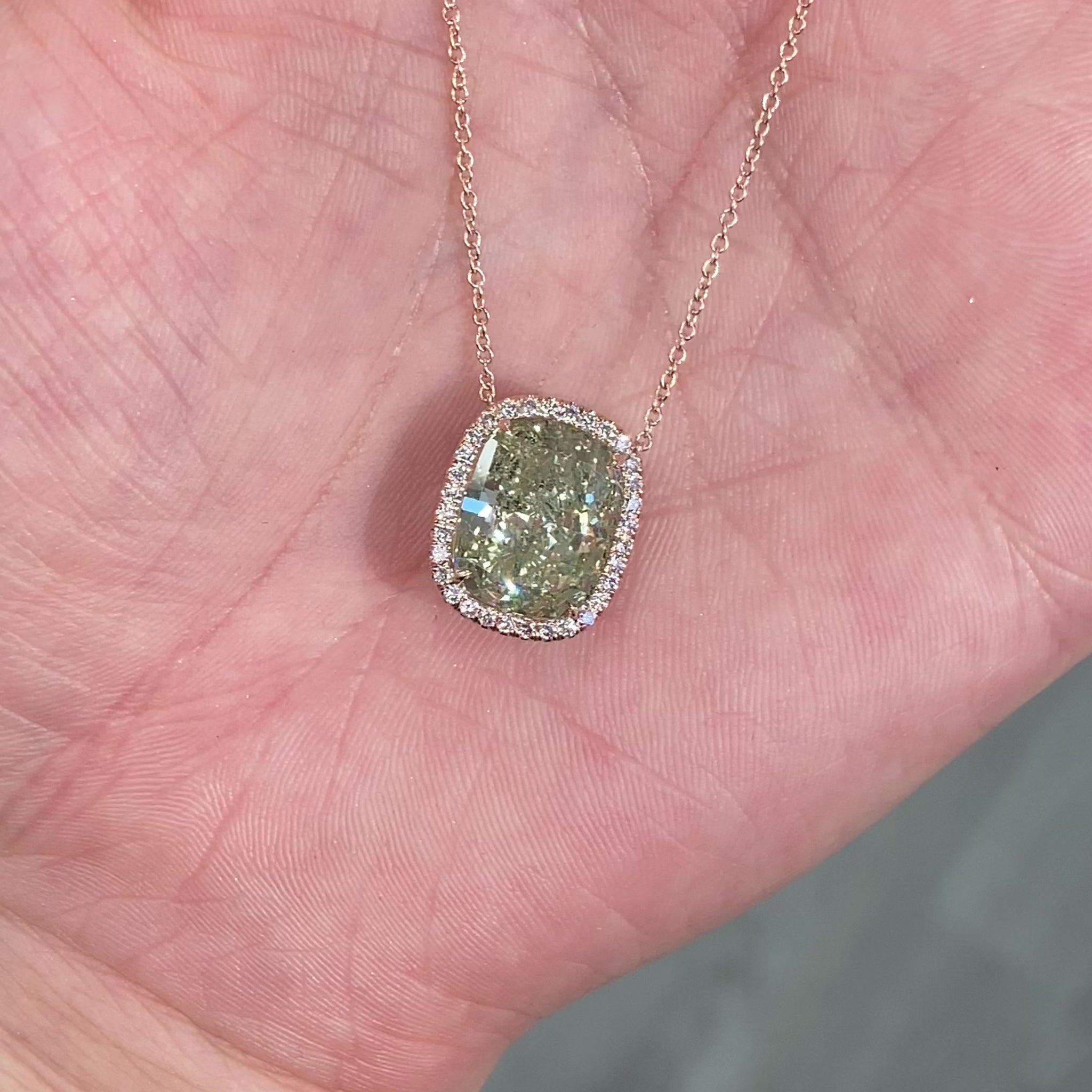 Elegant green cushion cut diamond pendant with a pink halo, featuring GIA-certified diamonds.