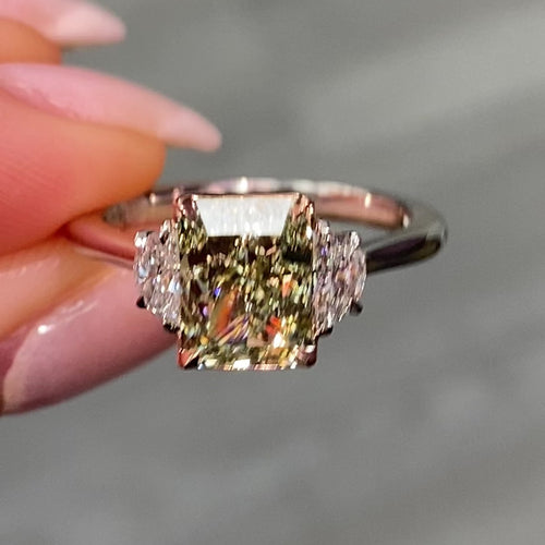 Natural green diamond engagement ring with a radiant cut center and yellow diamond accents.