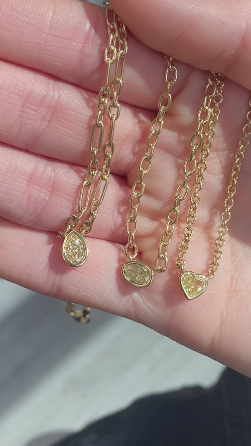 Canary diamond necklace, yellow pear shape diamond on a golden chain, bezel set yellow diamond