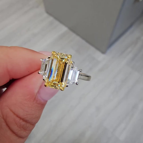 3 carat yellow diamond elongated emerald cut three stone ring with trapezoids