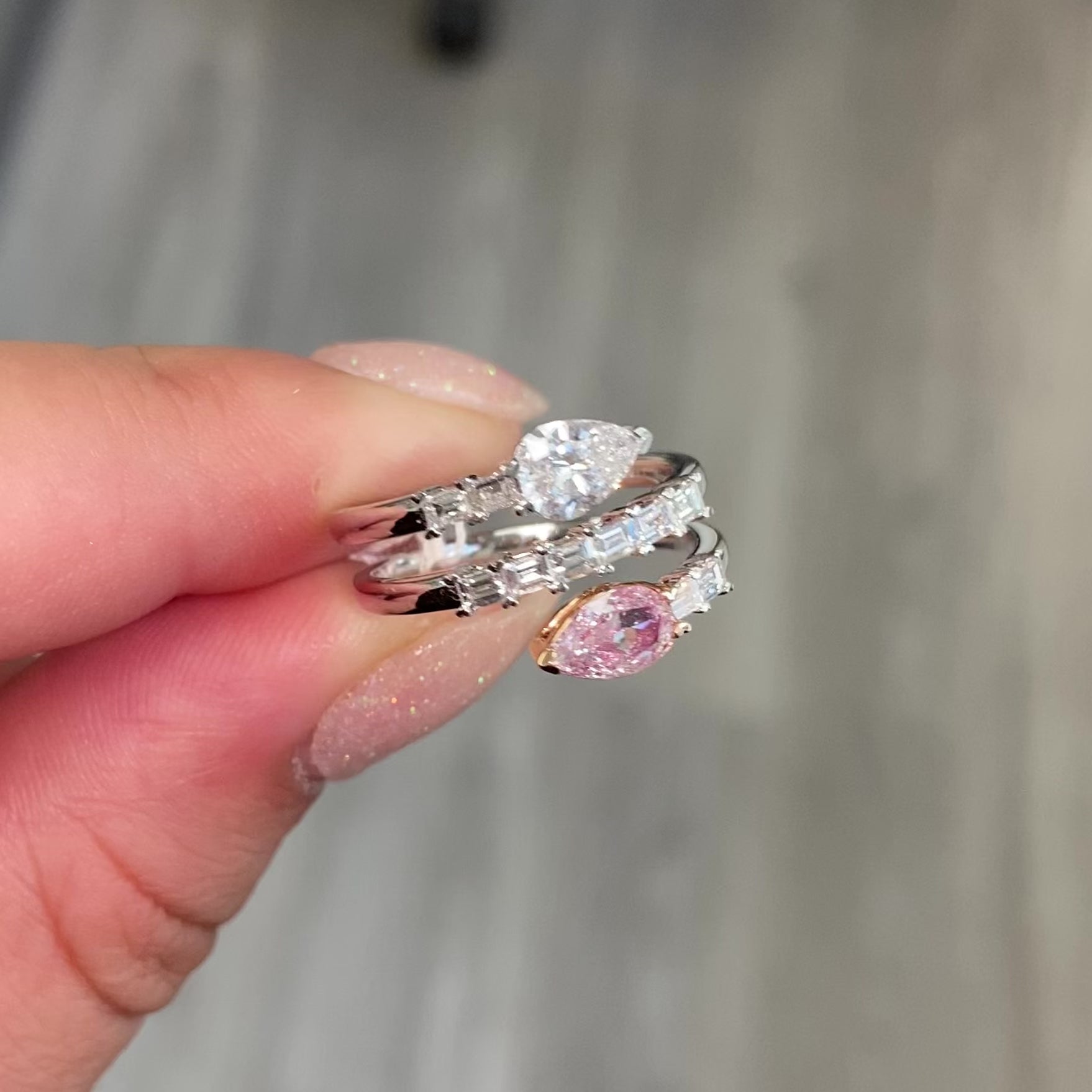 pink diamond statement ring, pink and white pear shape diamonds with emerald cut diamonds along the band 