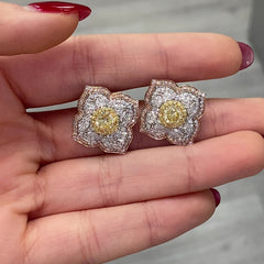 Light yellow and fancy light yellow diamond studs, in a flower theme with 1.5 carats of surrounding white and yellow diamonds