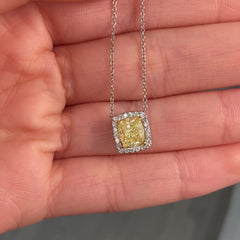 natural fancy light yellow cushion cut diamond in a white diamond halo on a 18k gold pendant