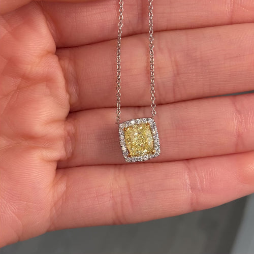 natural fancy light yellow cushion cut diamond in a white diamond halo on a 18k gold pendant