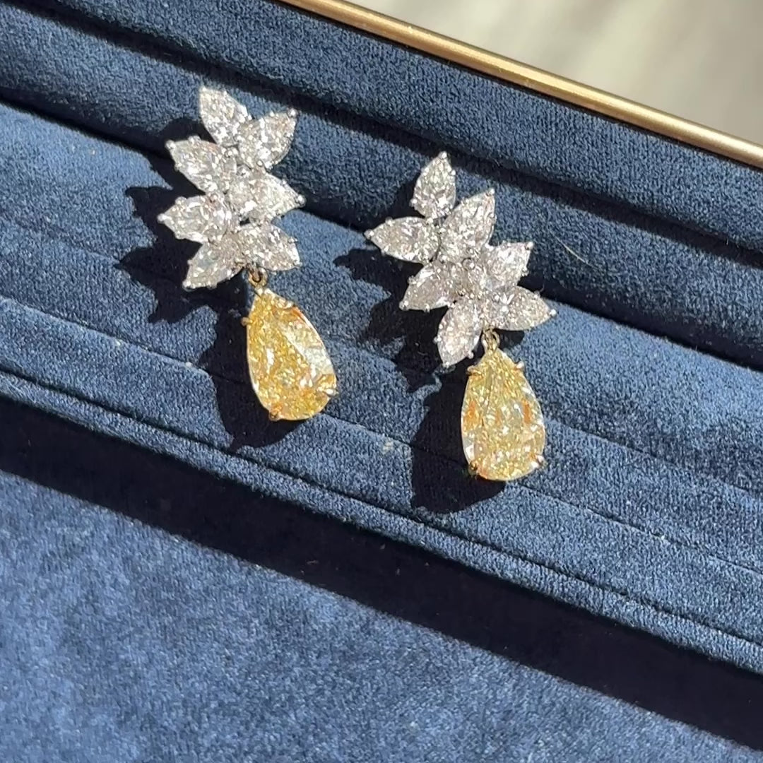 Fancy Light Yellow pear shape diamond earrings Natural yellow pear shape diamond cluster drop earrings with a total of 13.29 carats of natural white and yellow diamonds. Featuring 3 carat each, GIA Certified Fancy Light Yellow pear shape center diamonds with VS1 and VVS2 clarity.