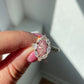 Pink marquise diamond ring with white pear shape diamonds surrounding