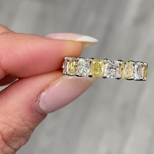 Elegant yellow and white radiant cut diamond eternity band featuring VS-VVS clarity.