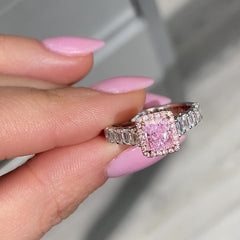 bubblegum pink diamond, pink radiant cut diamond surrounded by emerald cut and round diamonds, halo engagement ring with natural pink diamond