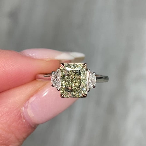 Natural greenish yellow diamond engagement ring featuring a radiant cut center stone with VVS2 clarity.