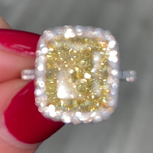 GIA certified natural canary yellow diamond ring surrounded by a halo of white diamonds.