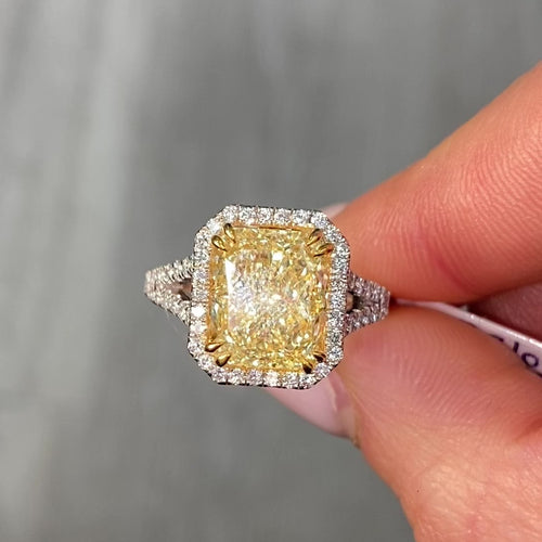 Light yellow radiant cut diamond engagement ring with a white diamond halo, VS2 clarity.