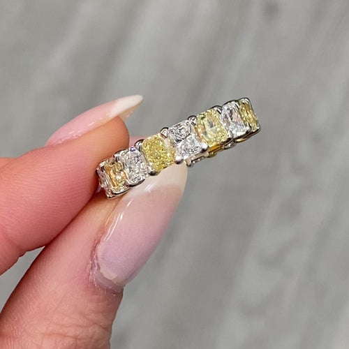 Elegant yellow and white radiant cut diamond eternity band featuring VS-VVS clarity.