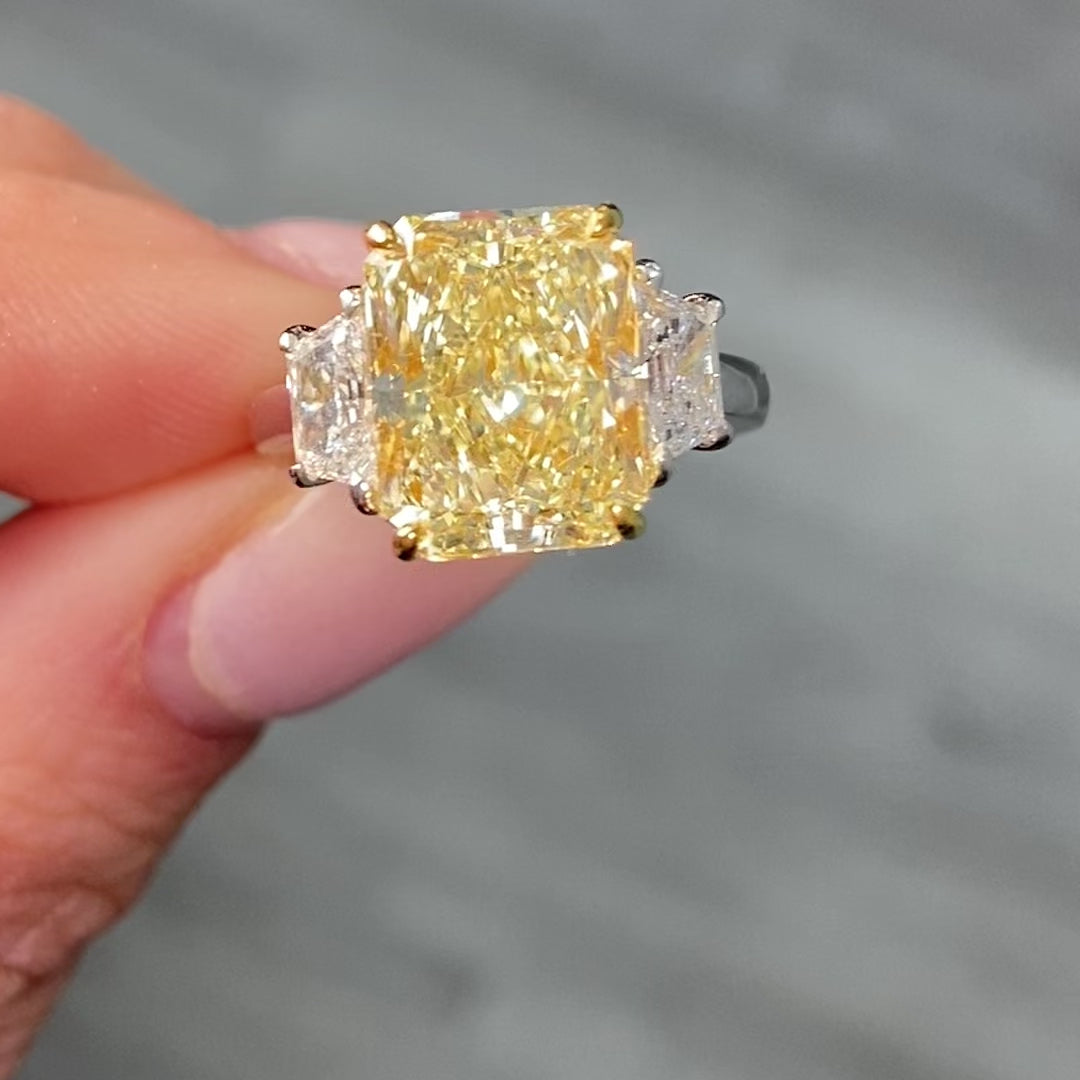 Elegant fancy light yellow elongated radiant diamond ring with VS2 clarity, unique and striking design.