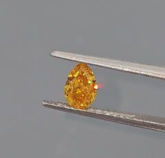 GIA certified fancy elongated yellow orange pear shaped diamond.