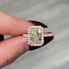 Fancy greenish-yellow radiant cut diamond halo ring with pink diamonds and VS2 clarity.