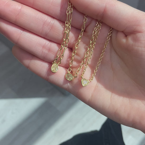 Canary diamond necklace, yellow heart shape diamond on a golden chain, bezel set yellow diamond