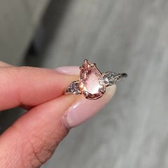 Unique three-stone ring with a deep brown-pink pear diamond and blue diamond accents, GIA certified.