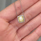 natural fancy light yellow cushion cut diamond in a white diamond halo on a 18k gold pendant