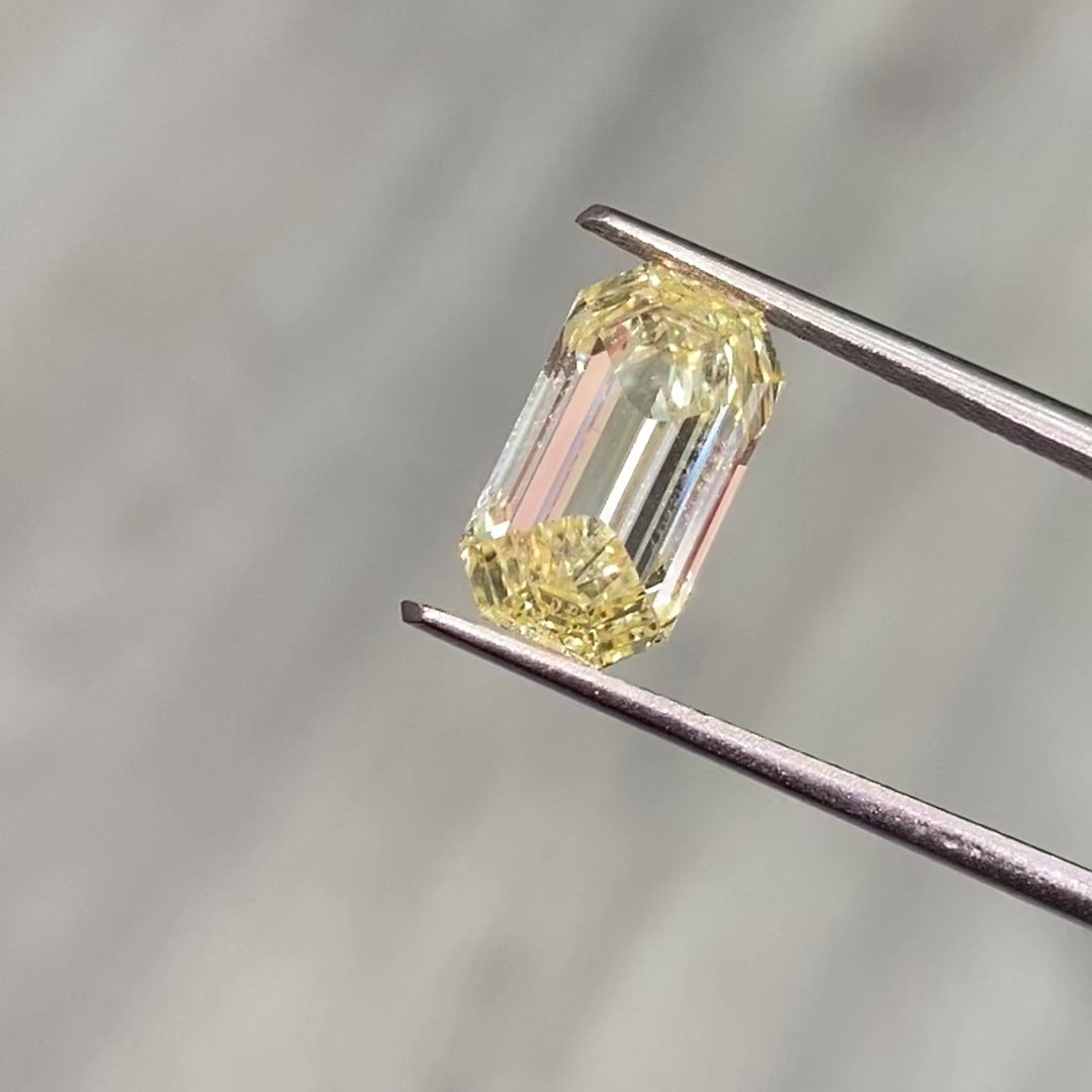 Elegant radiant yellow unique emerald cut with an elongated diamond, GIA certified, VS1 clarity.